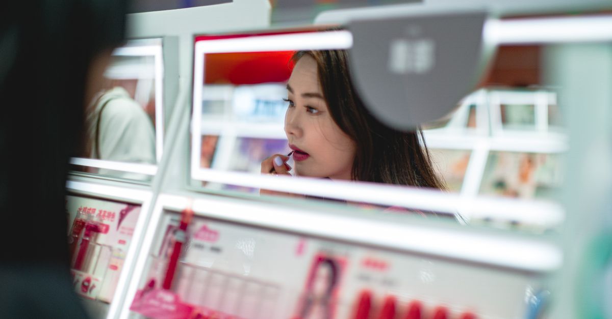 Woman using smartphone for virtual makeup try-on with AR technology