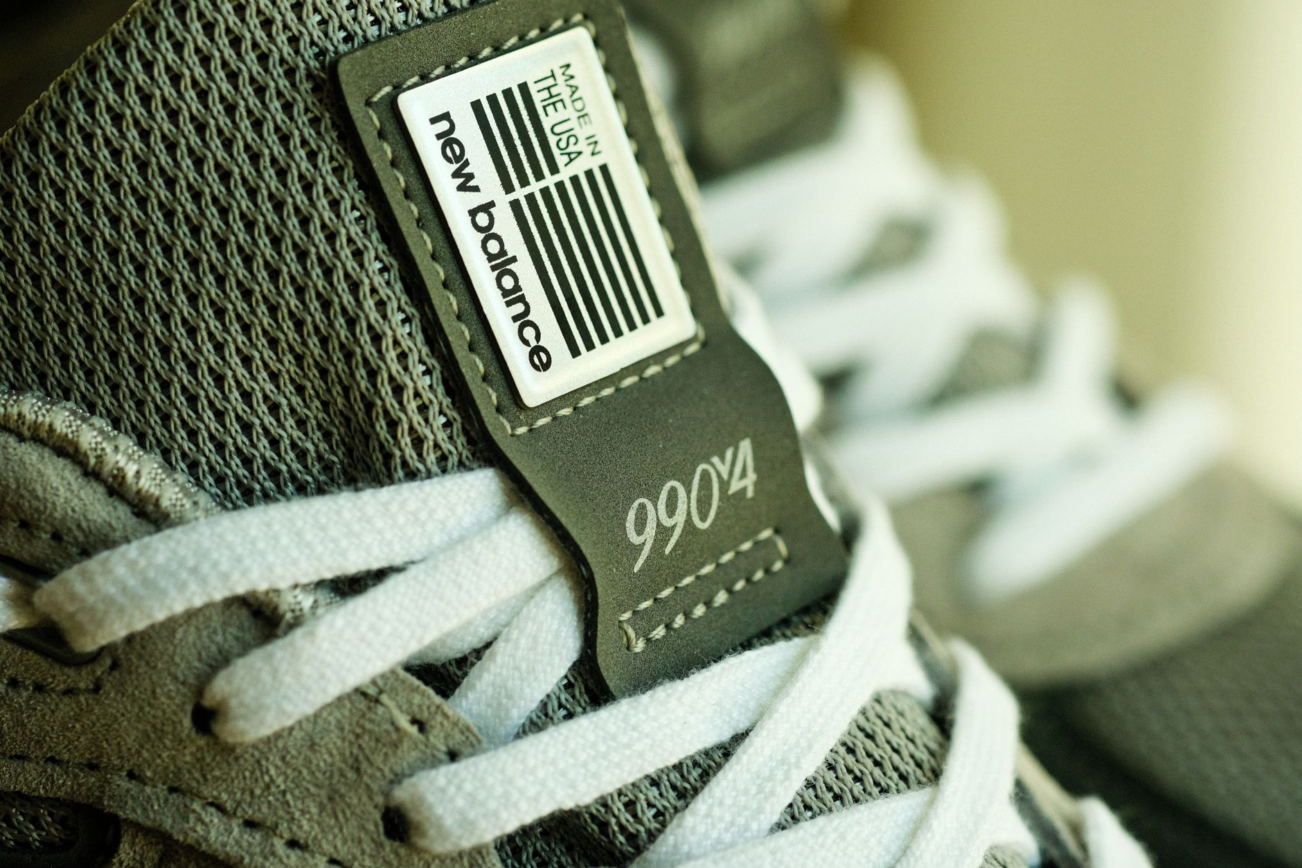 New Balance sneaker in dark colorway on a neutral background