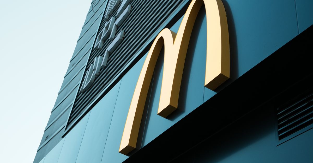 Modern McDonald's drive-through with digital ordering screen, artificial light at night