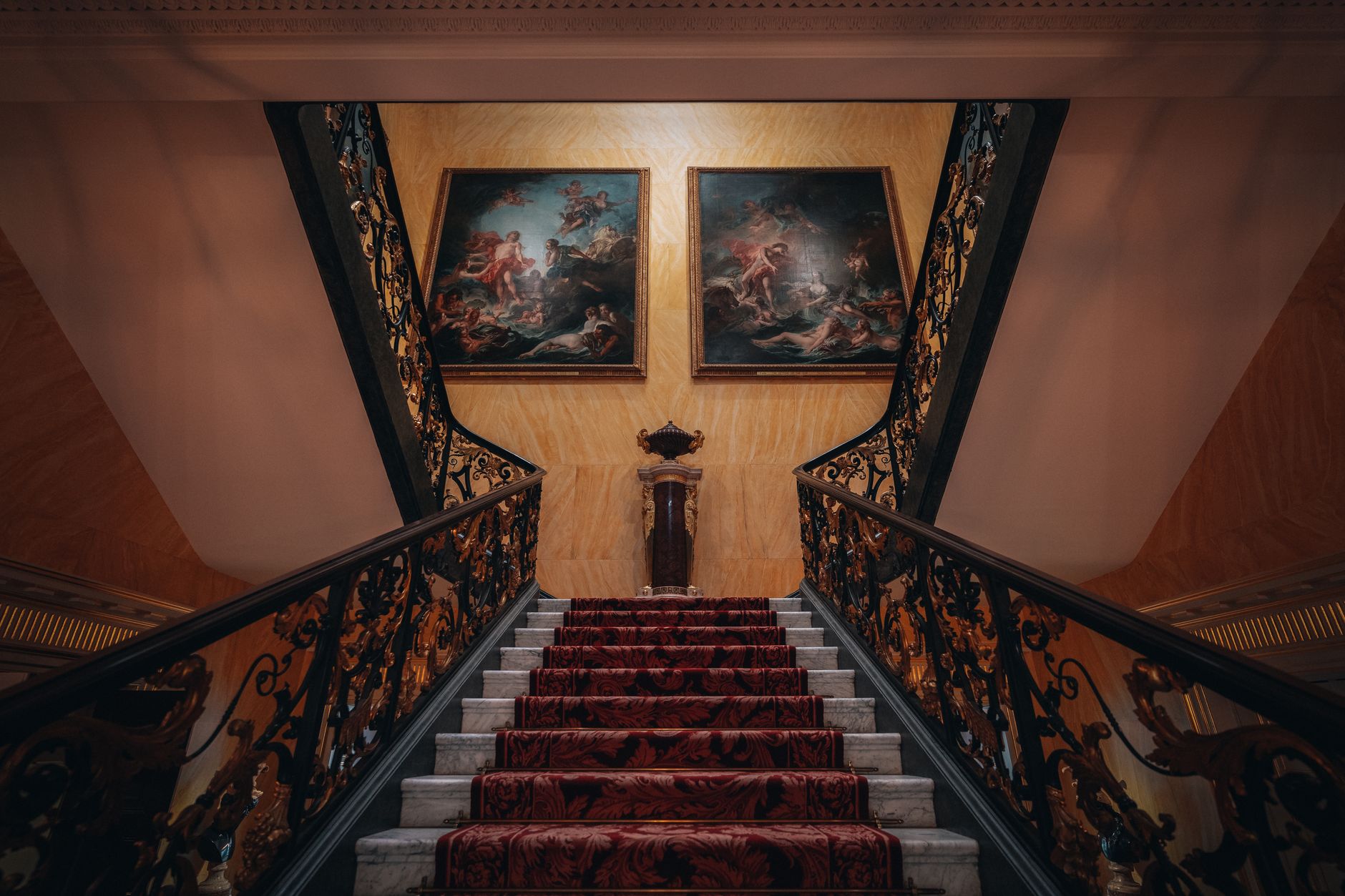 Luxurious staircase in London adorned with classic art, offering a glimpse into historic architecture.