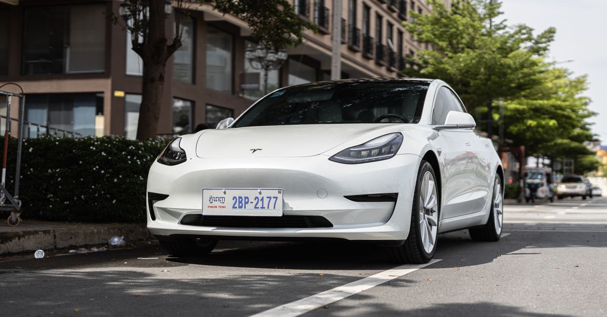 White Tesla vehicle on a California highway with desert landscape in the background