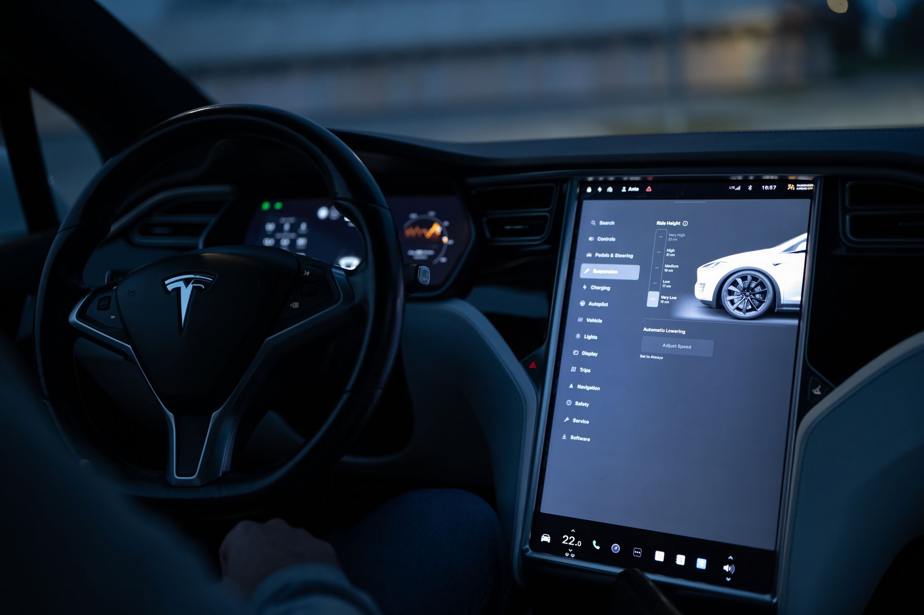 White Tesla Model Y at night, headlights on
